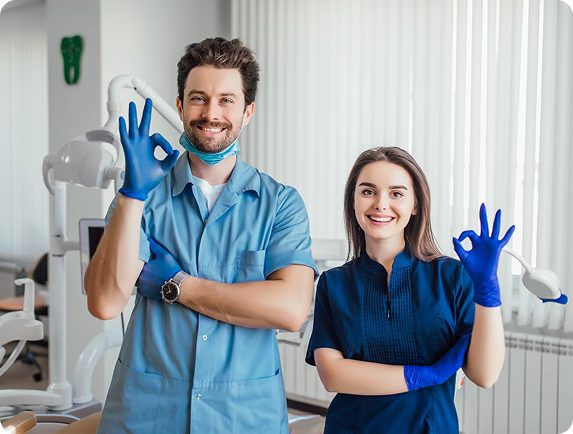 Three dental team members smiling in a dental office
